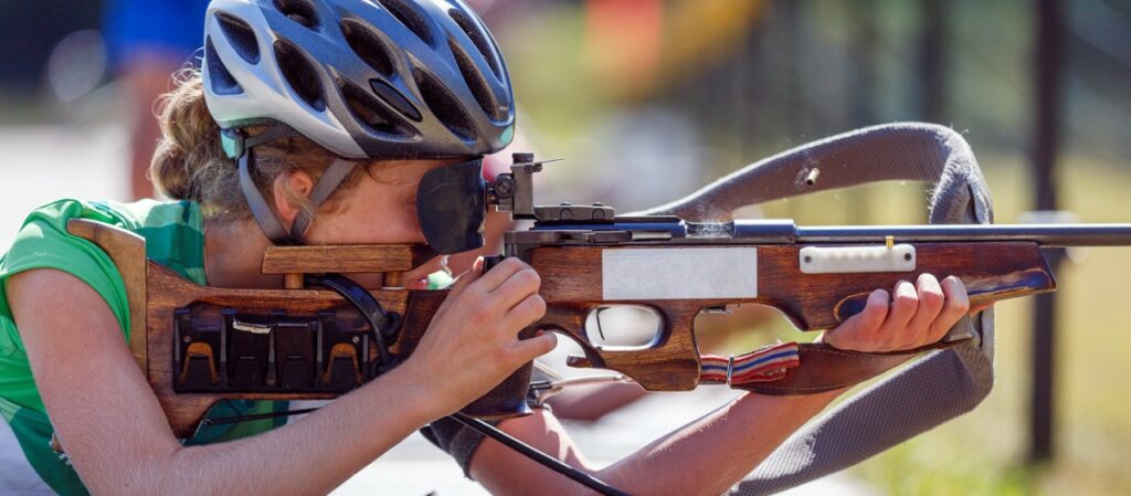 Athlète en pleine action lors d'une compétition de biathlon laser, visant précisément une cible électronique