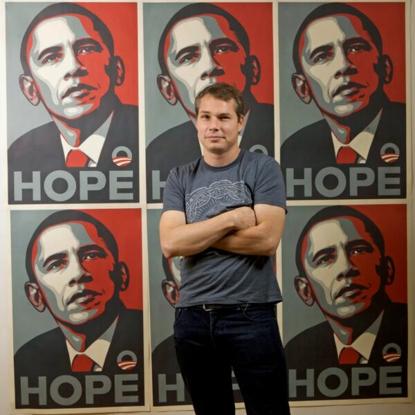 Photo de Shepard Fairey devant sa peinture de Barack Obama et son fameux Hope