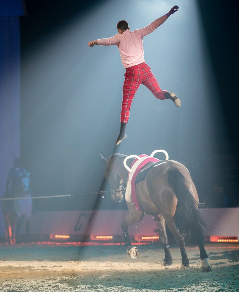 Acrobate équestre suspendu en l'air créant une image dynamique de mouvement et de grâce