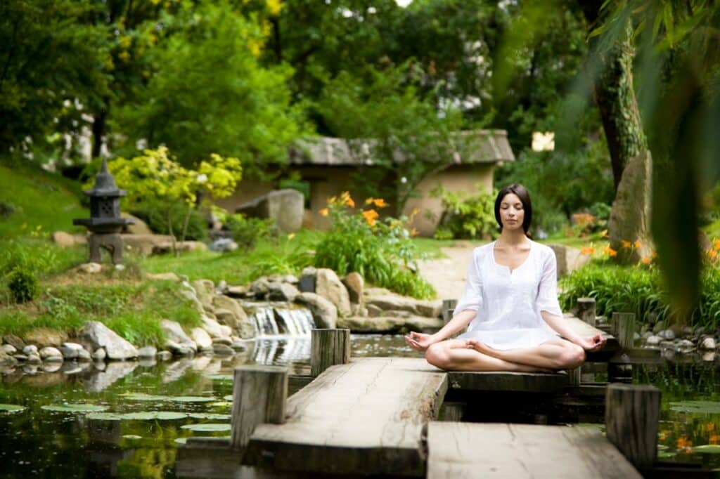 Femme méditant en position de lotus au lever du soleil