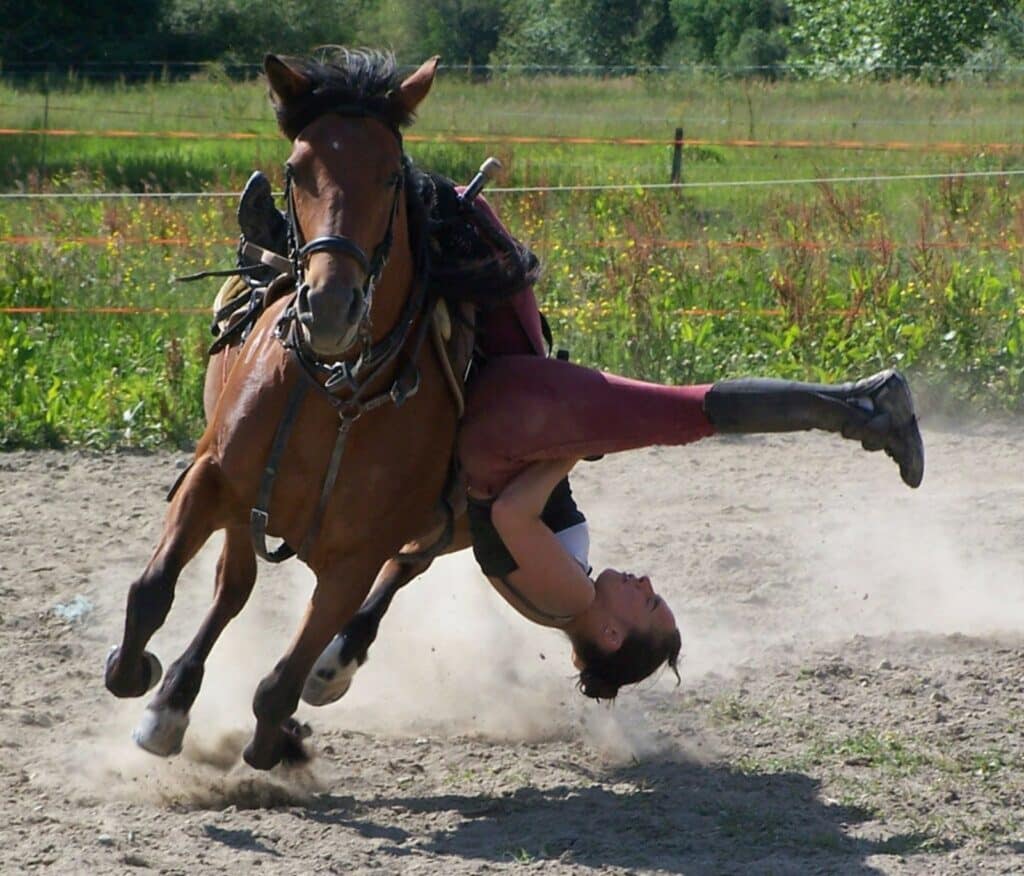 Jeune acrobate équestre en plein entraînement perfectionnant ses figures sur un cheval calme et patient